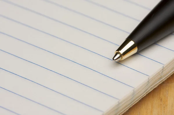 image shows a writing pad and a pen