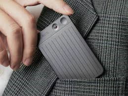 Image showing a plaud note device being held by a person's hand as they are putting it into a jacket pocket